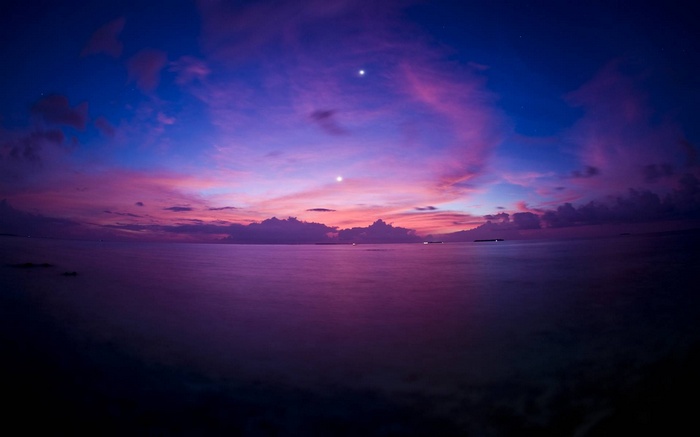 Purple sunset over the sea with two bright stars