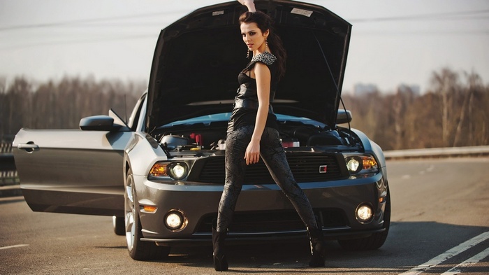 Woman posing with a Ford Mustang with hood open