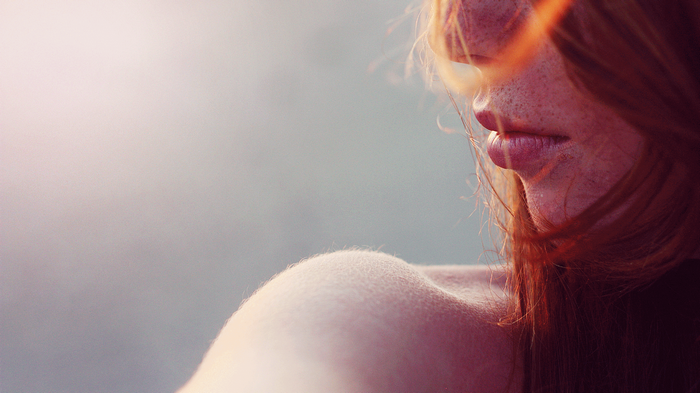 Redhead woman with freckles and bare shoulders