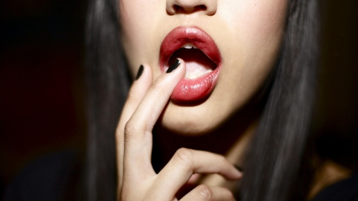 Woman with red lipstick and black painted nails