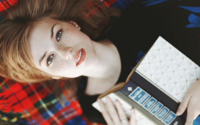 Woman with freckles reading a book