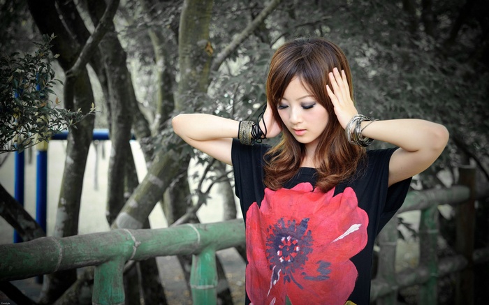 Asian woman with hands on head wearing bracelets