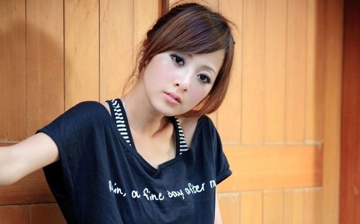 Mikako Zhang Kaijie posing in front of a wooden wall