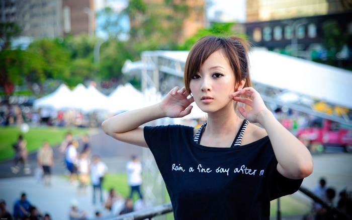 Asian woman with arms up in black shirt