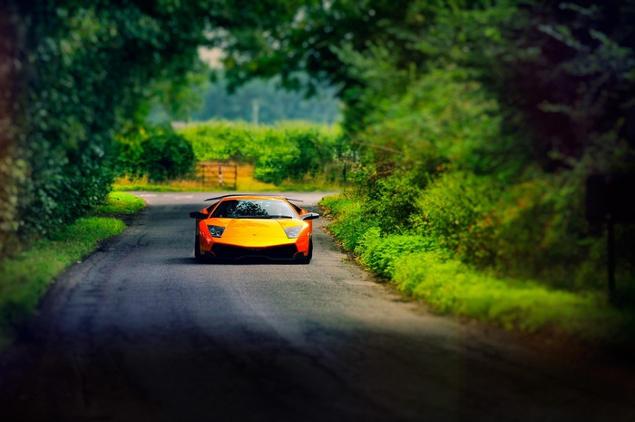 Orange Lamborghini Murcielago driving on a country road