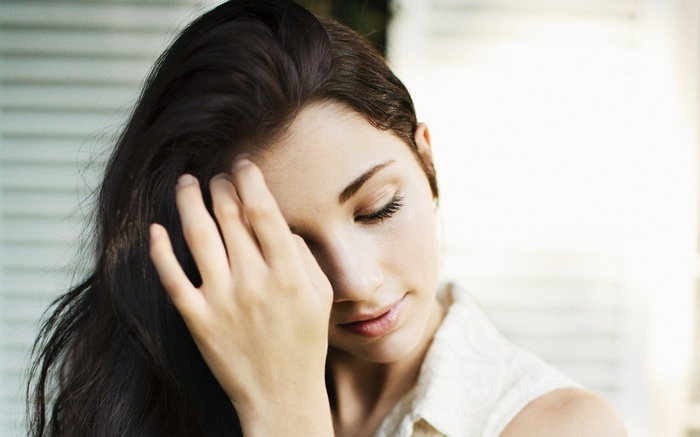Emily Rudd with her hand in her dark hair