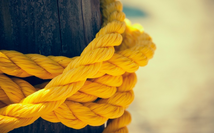 Thick yellow rope tied around a wooden post