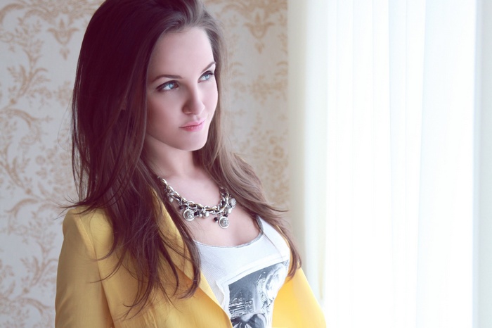 Woman with blue eyes and brunette hair wearing a necklace