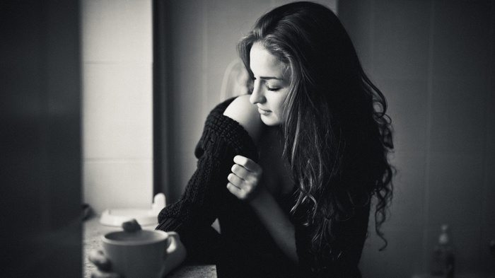 Monochrome photo of a woman with long hair holding a cup