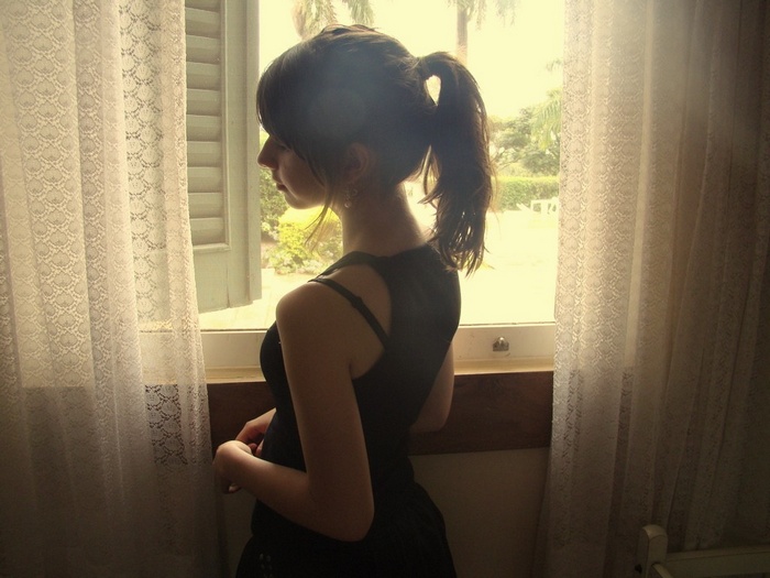 Brunette woman with ponytail looking out window