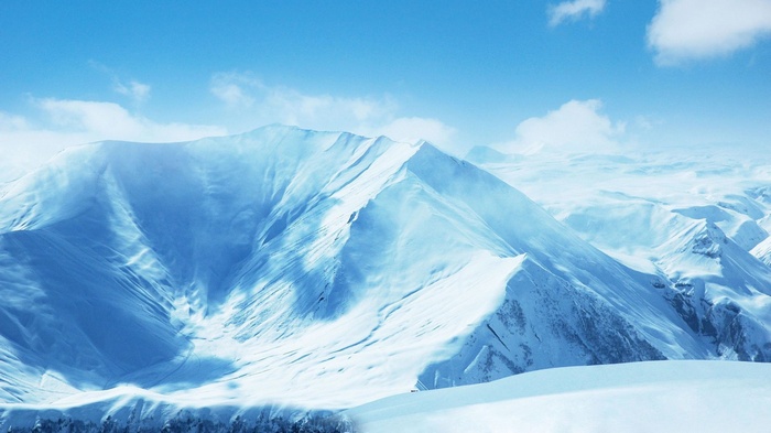Snowy mountains under a blue sky with clouds