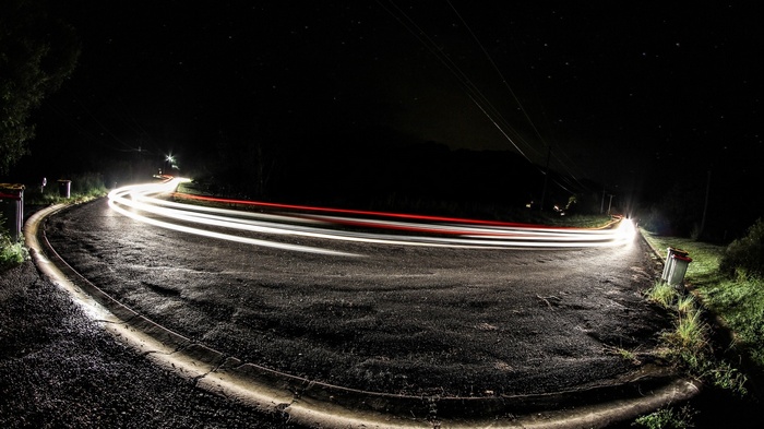 Long exposure photography of light trails on a wet road at night