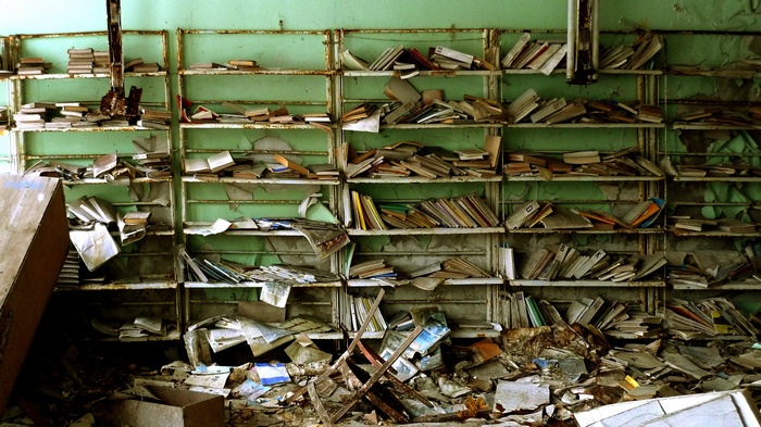 Abandoned library with decaying books and shelves