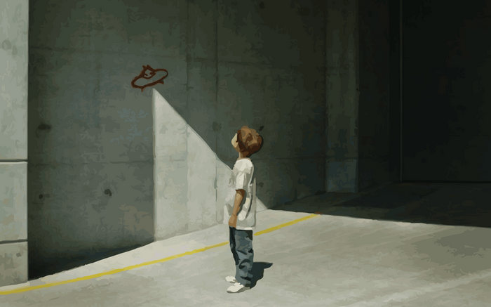 Child looking at Banksy-style artwork on a concrete wall