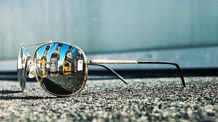 Sunglasses reflecting bottles of Jack Daniels whiskey