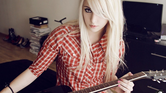 Bessy Suicide plays guitar in a red plaid shirt