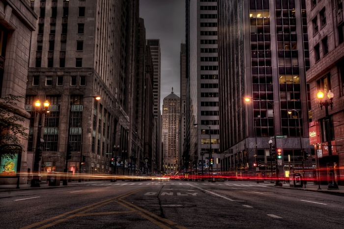 City street with light trails and tall buildings