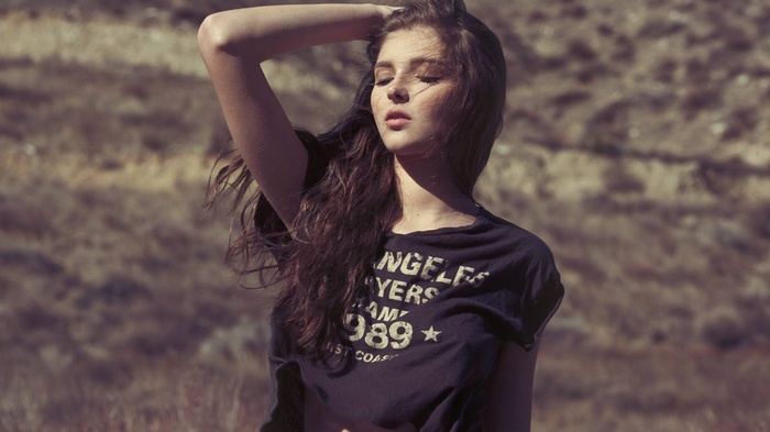 Woman with long hair wearing a printed t-shirt outdoors
