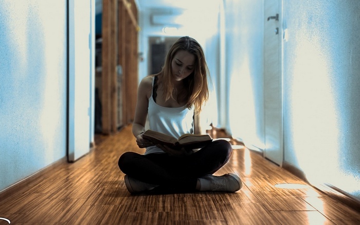 Woman sitting on the floor reading a book