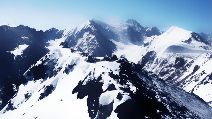 Snow-covered mountains under a clear blue sky