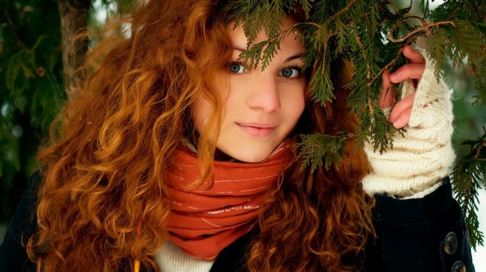 Redhead woman with blue eyes in winter forest