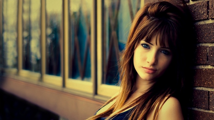 Susan Coffey leans against a brick wall