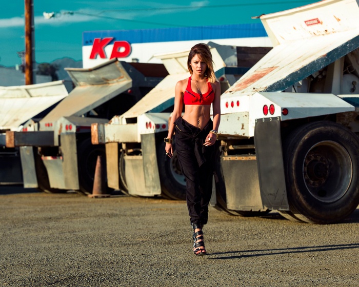 Vanessa Hudgens walks past dump trucks