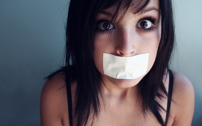 Woman with white tape over her mouth