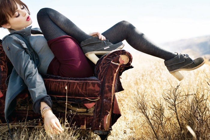 Emma Stone sitting on a vintage chair in a field