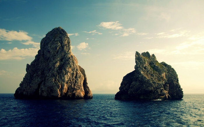 Two rocky islands in the sea under a cloudy sky