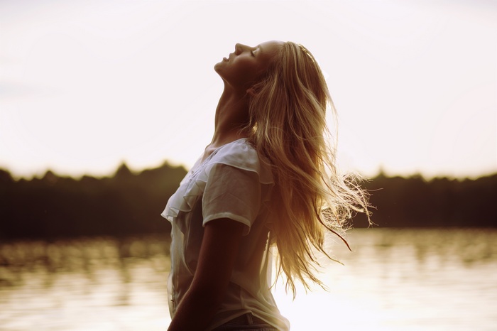 Woman with long blonde hair looking up outdoors