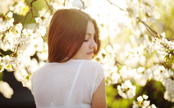 Woman in white shirt with white flowers and sunlight