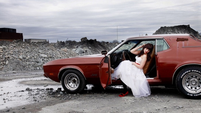 Woman in wedding dress with red Ford Mustang