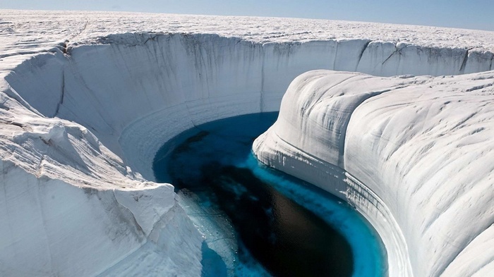 A deep blue river carved into a vast ice canyon