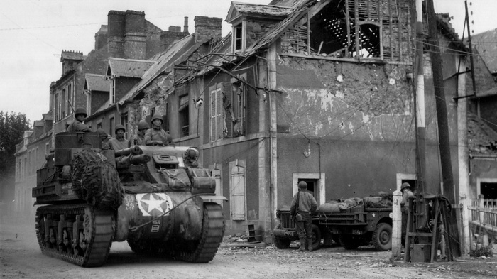 World War II soldiers in a tank and jeep in a ruined town