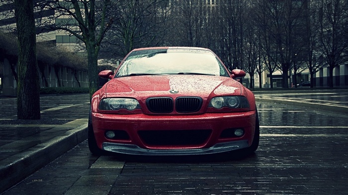 Red BMW M3 E46 parked on a wet city street