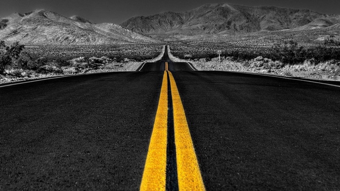 Desert road with mountains and selective coloring