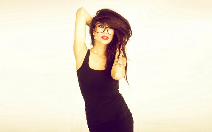 Alie Layus with glasses and arms up