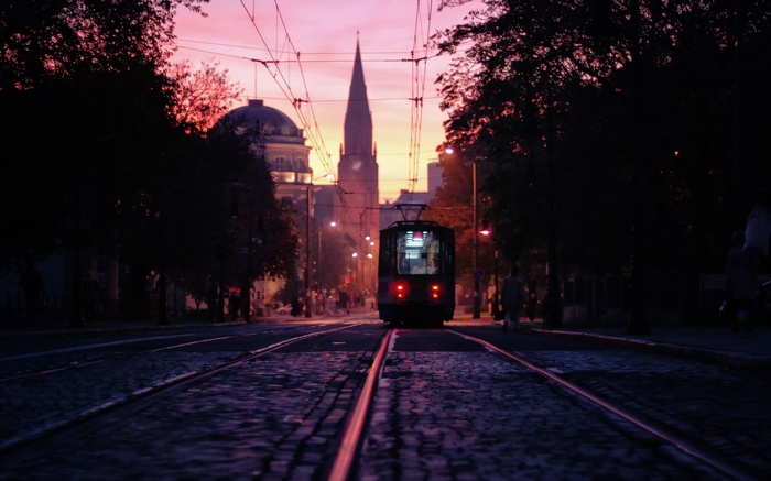 Tram in Poznan at dusk with church and university