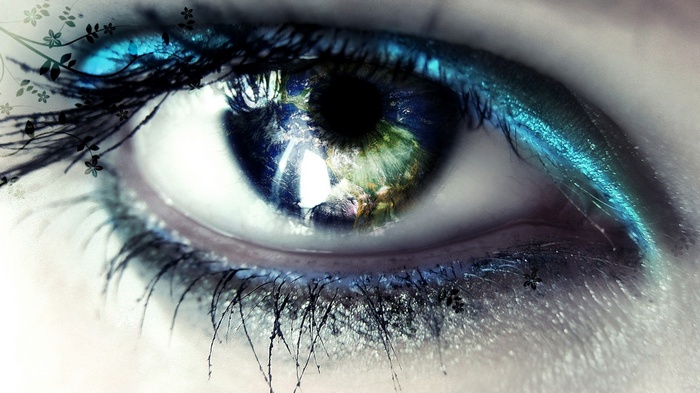 Close-up of a woman's eye with the Earth reflected in the pupil