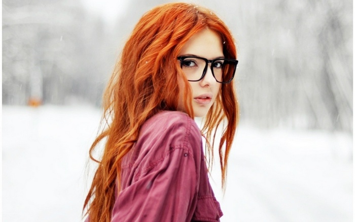 Redhead woman with glasses in the snow