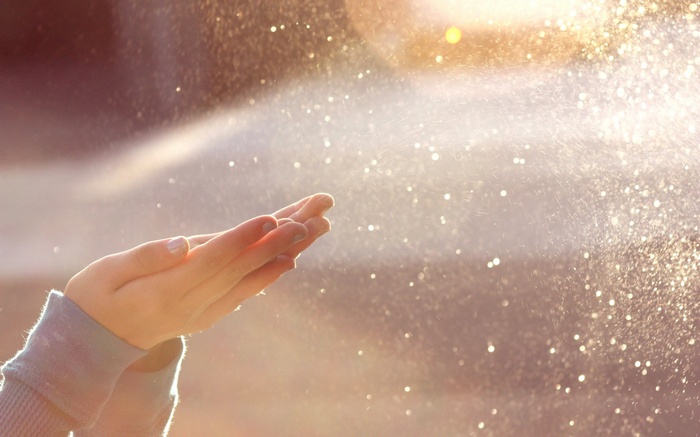 Hands catching sunlight and glitter