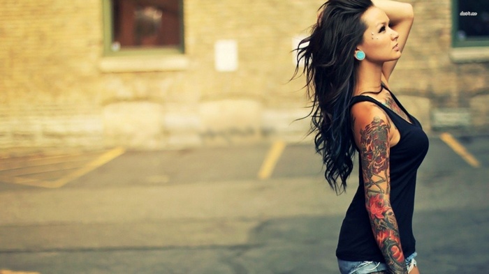 Woman with dark hair and tattoos