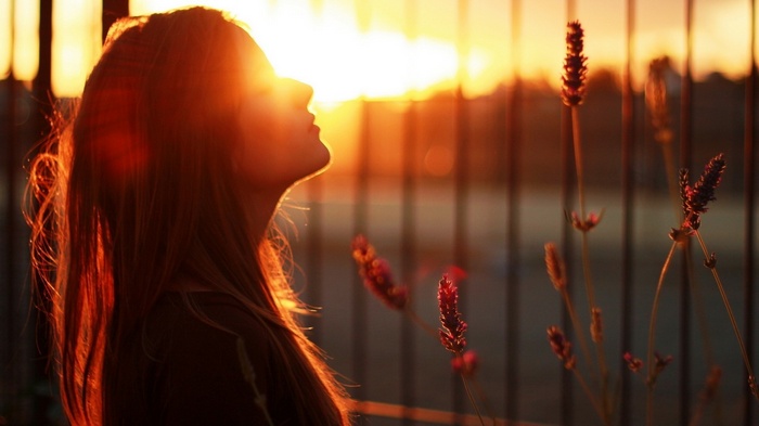Woman in sunlight at sunset with plants