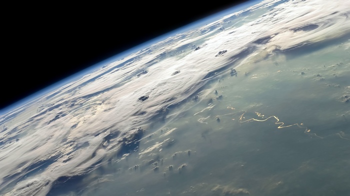 Earth's atmosphere seen from space with clouds and rivers