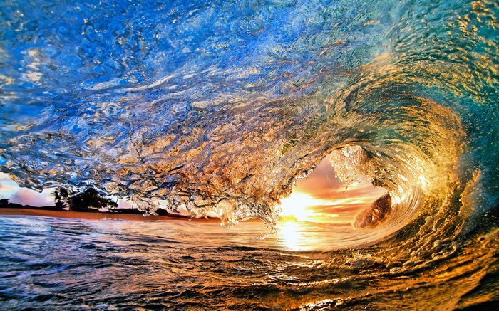 Wave crashing at sunset with sunlight
