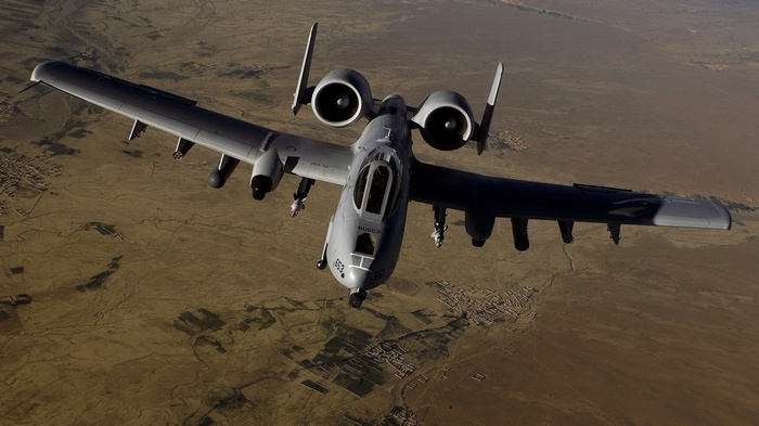 Fairchild Republic A-10 Thunderbolt II flying over desert landscape