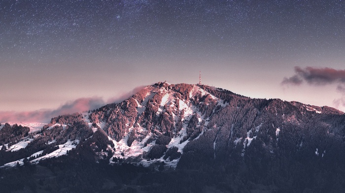 Snow-covered mountain peak under a starry sky