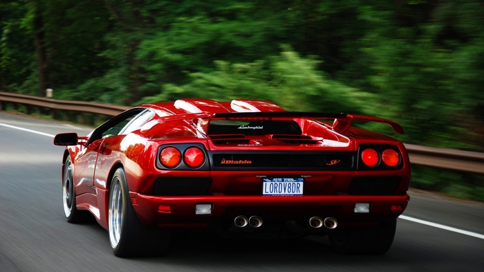 Red Lamborghini Diablo SV driving on a road