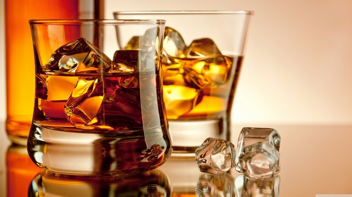 Whiskey in glasses with ice cubes